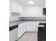 Well-lit kitchen featuring white cabinets and updated appliances at 5099 S Linden Dr, Englewood, CO 80110