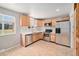 Kitchen featuring stainless appliances, wood cabinets, tile backsplash and tile flooring at 16720 E Layton Ave, Aurora, CO 80015