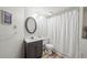 Clean bathroom with an oval mirror, vanity, shower with curtain, and neutral-toned walls at 6808 Silverleaf Ave, Firestone, CO 80504