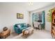 Stylish bedroom with a blue sofa, desk, and a window providing natural light at 6808 Silverleaf Ave, Firestone, CO 80504
