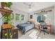 Bright bedroom with a ceiling fan, light colored carpet, a workspace, and multiple windows providing natural light at 6808 Silverleaf Ave, Firestone, CO 80504