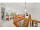 Bright hallway featuring hardwood railing, neutral carpet, and views of the neighborhood at 6808 Silverleaf Ave, Firestone, CO 80504