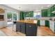 Bright kitchen features green cabinets, butcher block island, and sliding doors to the outdoor deck at 6808 Silverleaf Ave, Firestone, CO 80504