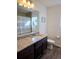 Stylish bathroom features granite counters, wood floors, and framed mirror above the sink at 10052 Zeno St, Commerce City, CO 80022