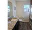 Bathroom featuring granite counters, wood floors, sink and neutral decor at 10052 Zeno St, Commerce City, CO 80022