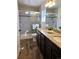 Bright bathroom featuring double vanity with granite countertops, tiled floors, and glass shower at 10052 Zeno St, Commerce City, CO 80022