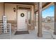 Welcoming front door with wreath, sidelight window, brick accents, and a covered porch, creating a warm entrance at 10052 Zeno St, Commerce City, CO 80022