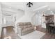 Bright living room featuring a comfortable sofa, hardwood floors, and an open layout leading to the kitchen and entry at 10052 Zeno St, Commerce City, CO 80022