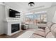 Inviting living room featuring large windows, fireplace, comfortable seating, and abundant natural light at 10052 Zeno St, Commerce City, CO 80022
