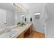 Bright bathroom with double sinks, a large mirror, and a window offering natural light and ventilation at 9676 Whitecliff Pl, Highlands Ranch, CO 80129