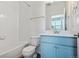 Bright bathroom with a blue vanity, bathtub, and toilet at 6870 Merseyside Ln, Castle Pines, CO 80108