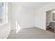 Clean bedroom with neutral carpet, white walls, and a glimpse of the bathroom at 6870 Merseyside Ln, Castle Pines, CO 80108