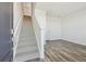 Welcoming entryway with a staircase and beautiful wood-look floors. Door to unfinished basement at 6870 Merseyside Ln, Castle Pines, CO 80108