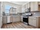 Modern kitchen with gray cabinets, stainless steel appliances, and wood-look floors at 6870 Merseyside Ln, Castle Pines, CO 80108