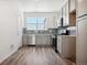 Modern kitchen with gray cabinets, stainless steel appliances, and wood-look floors at 6870 Merseyside Ln, Castle Pines, CO 80108