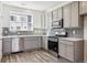 Well-lit kitchen featuring gray cabinets, stainless steel appliances, and light countertops at 6870 Merseyside Ln, Castle Pines, CO 80108