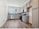 Modern kitchen with gray cabinets, stainless steel appliances, and wood-look floors at 6870 Merseyside Ln, Castle Pines, CO 80108