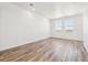 Spacious living room with wood-look floors and large windows offering plenty of natural light at 6870 Merseyside Ln, Castle Pines, CO 80108