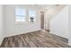 Bright living room with beautiful wood-look floors and large windows. Available sign in window at 6870 Merseyside Ln, Castle Pines, CO 80108