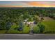 Expansive property with manicured lawn, mature trees, and a sprawling home under a beautiful sunset at 4600 S University Blvd, Englewood, CO 80113