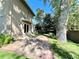 View of backyard featuring brick patio, mature trees, and lush landscaping, a tranquil outdoor space at 4600 S University Blvd, Englewood, CO 80113