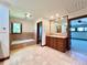 Bright bathroom featuring a bathtub, vanity, and a large mirror at 4600 S University Blvd, Englewood, CO 80113