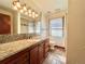 Bathroom vanity with granite countertop and undermount sink with tiled floor and large mirror at 4600 S University Blvd, Englewood, CO 80113