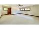 Large bedroom with neutral carpet, base molding, and natural light from the windows at 4600 S University Blvd, Englewood, CO 80113