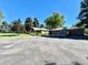 Expansive home exterior showcasing a circular driveway, well-manicured lawn, and a three-car garage at 4600 S University Blvd, Englewood, CO 80113