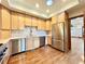 Modern kitchen with stainless steel appliances, light wood cabinets, and hardwood floors at 4600 S University Blvd, Englewood, CO 80113