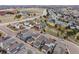 An elevated view captures a modern neighborhood's layout, roads, and surrounding land with distant buildings at 9694 Dunning Cir, Highlands Ranch, CO 80126