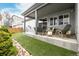 Relaxing backyard with artificial turf, landscaping, and a covered patio with furniture and a swing at 9694 Dunning Cir, Highlands Ranch, CO 80126