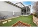 Expansive backyard featuring artificial turf, a covered patio with furniture, and a garden area at 9694 Dunning Cir, Highlands Ranch, CO 80126