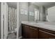 Modern bathroom featuring wood vanity, quartz counters, large mirror, and decorative art at 9694 Dunning Cir, Highlands Ranch, CO 80126