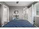 Neutral bedroom with blue bedding and modern shutters, and easy access to en-suite bath at 9694 Dunning Cir, Highlands Ranch, CO 80126