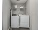 Practical laundry room featuring a washer, dryer, shelf, and modern tiled flooring at 9694 Dunning Cir, Highlands Ranch, CO 80126