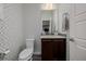 Chic powder room featuring patterned wallpaper, modern vanity and a decorative mirror at 9694 Dunning Cir, Highlands Ranch, CO 80126