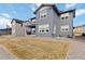 Backyard showcasing the house's exterior, brown lawn, and hardscaped surrounding at 4781 Saddle Iron Rd, Castle Rock, CO 80104