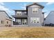Home backyard with a covered porch, patio doors, and well-maintained yard at 4781 Saddle Iron Rd, Castle Rock, CO 80104