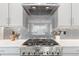 Modern kitchen featuring a stainless steel stove, hood, and updated backsplash at 4781 Saddle Iron Rd, Castle Rock, CO 80104