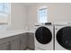 Well-lit laundry room featuring modern washer and dryer, ample counter space, and storage cabinets at 4781 Saddle Iron Rd, Castle Rock, CO 80104