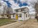 Charming two-story home with a yellow door, a paved driveway, and a detached garage at 5570 Otis Ct, Arvada, CO 80002