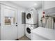 Efficient laundry room with stacked washer and dryer, plus storage space and backyard access at 5570 Otis Ct, Arvada, CO 80002