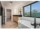 The primary bathroom features a soaking tub, vanity, and modern lighting at 1459 W 42Nd Ave, Denver, CO 80211