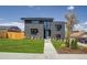 Contemporary two-story home showcasing a manicured lawn and sleek architectural design with a gray facade at 1459 W 42Nd Ave, Denver, CO 80211