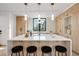 Modern kitchen featuring a large island with seating and stylish pendant lighting over white countertops at 1459 W 42Nd Ave, Denver, CO 80211