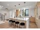 Modern kitchen featuring a large island with seating and stylish pendant lighting over white countertops at 1459 W 42Nd Ave, Denver, CO 80211