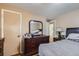 Bedroom featuring wood floors, tan walls, door, dark dresser, and mirror at 2560 Westchester Dr, Denver, CO 80221