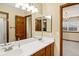 Bathroom with double sinks, wood cabinets, and a large mirror with views into another room at 4498 Buena Vista Ct, Castle Rock, CO 80109