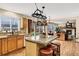 Spacious kitchen with wood cabinets, island with seating, and view into the living room at 4498 Buena Vista Ct, Castle Rock, CO 80109